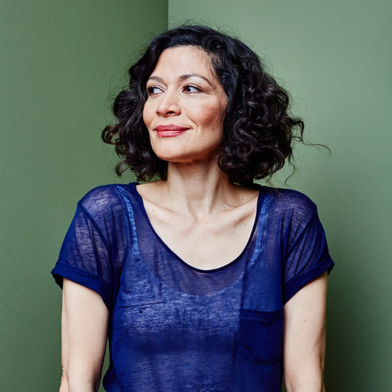 woman smiling with dark hair looking off to the side