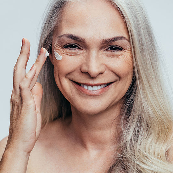 woman putting on cream face